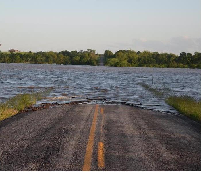 a long roadway completely submerged in flood waters