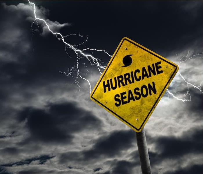 a yellow hurricane sign with dark storm clouds in the background 